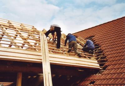 Workers attach wooden slats on the roof