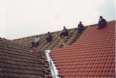 Helfer warten auf die nächsten Dachziegeln